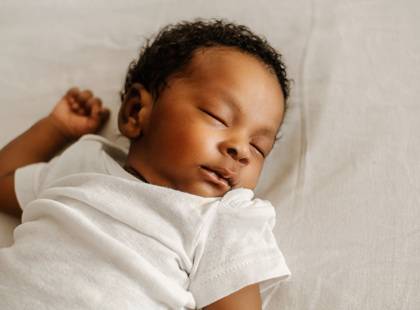Newborn asleep on their back.