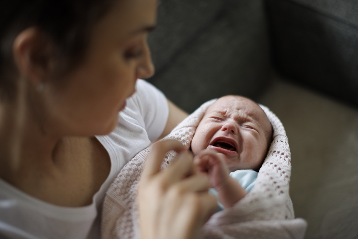 Newborn baby crying in mother's hands