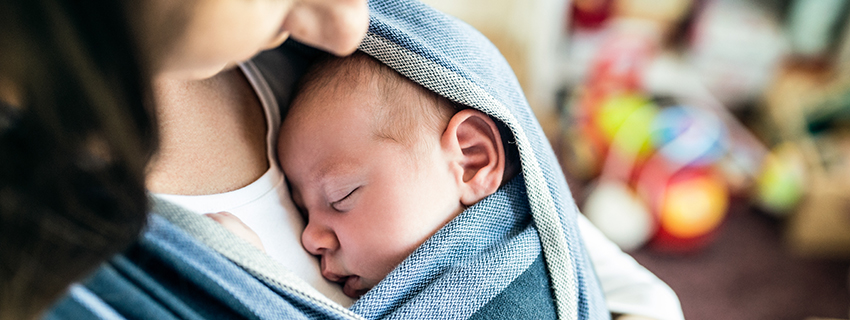 Mother with her baby in a baby sling.