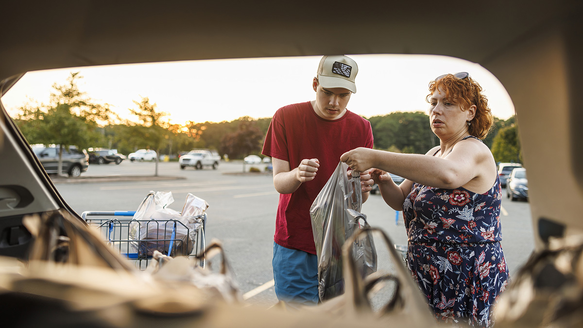 Mother and autistic teen collaborate during family shopping trip.