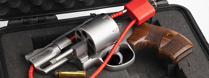 Hand gun with cable key locked on case background