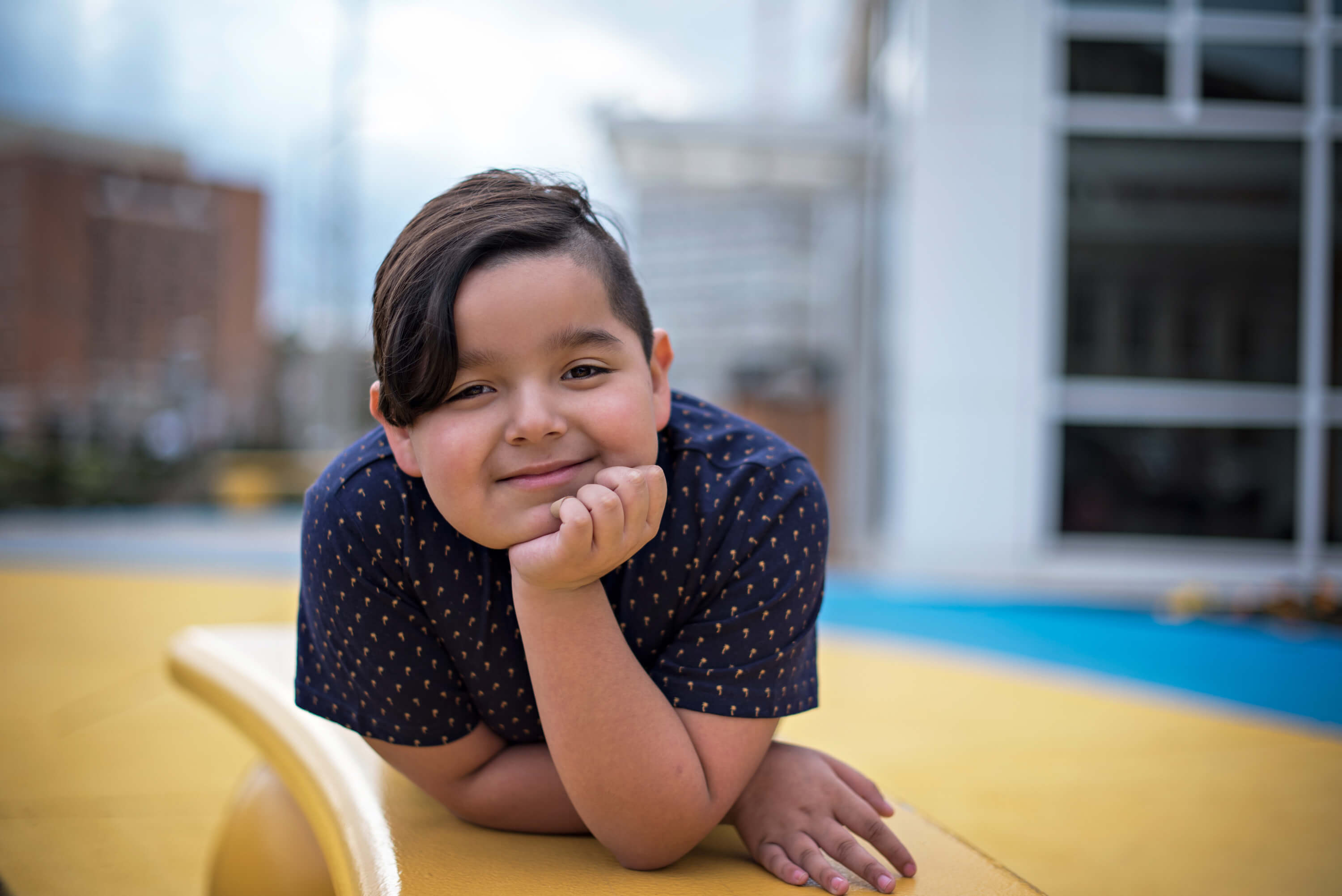 CHKD patient photo outside on the bench in front of the hospital.