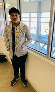 Young happy boy wearing grey sweatshirt.