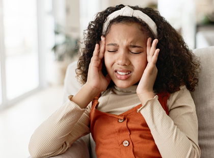 Young girl, headache and sofa with stress in anxiety, pain or distress for noise at home.