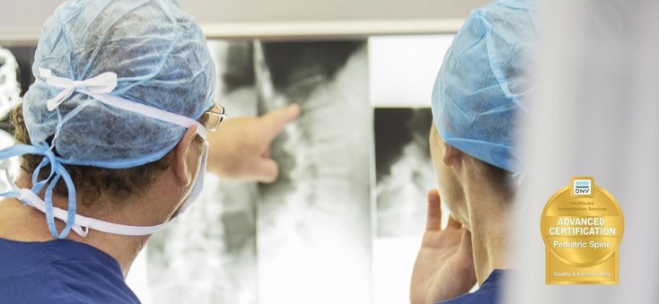 Surgeons looking at X-ray of a Spine