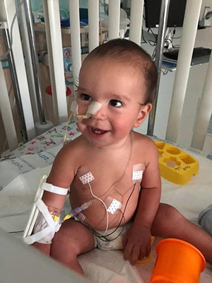 Colton Harwood smiling in his crib at CHKD