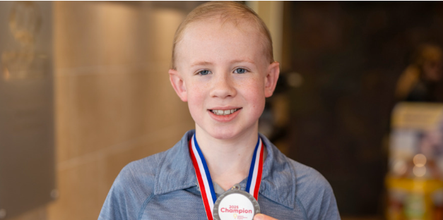 Tucker Davis showing off his champion medal.