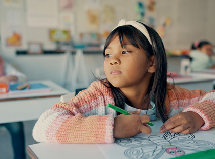 Thinking girl drawing in classroom with notebook, growth and development in education