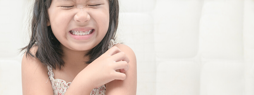 Girl scratching her arm in pain