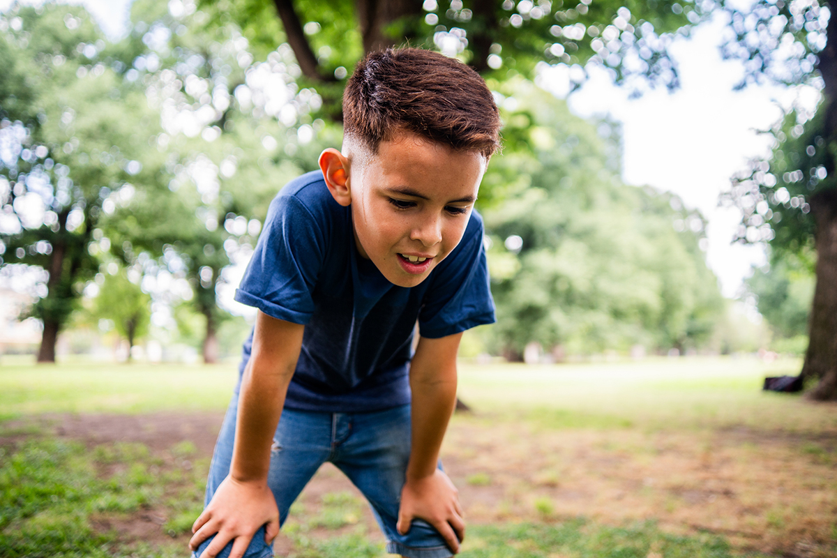 Young boy catches his breath outside