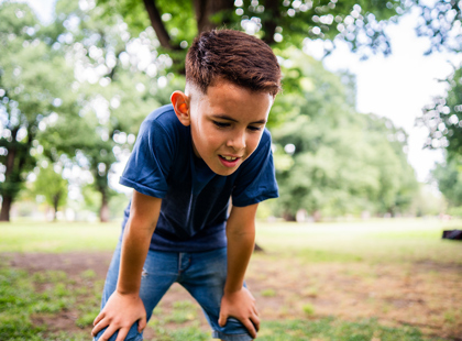 Young boy catches his breath outside