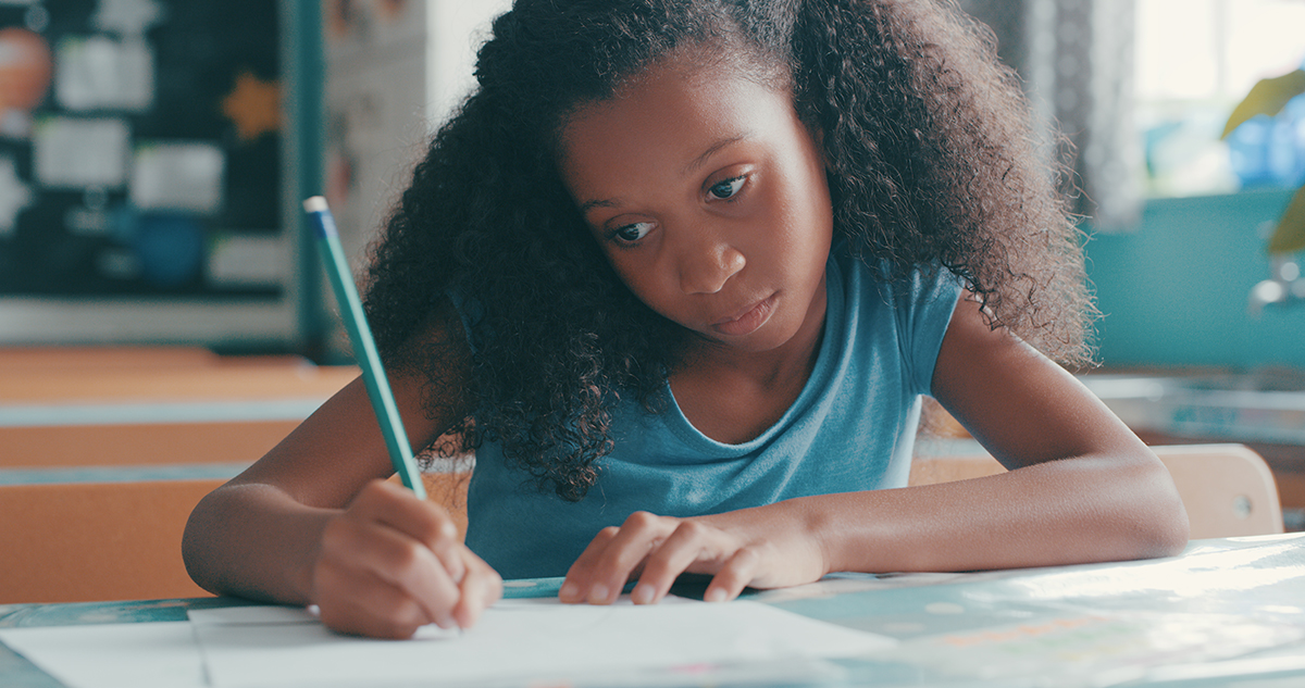 Shot of a young girl focusing on doing schoolwork