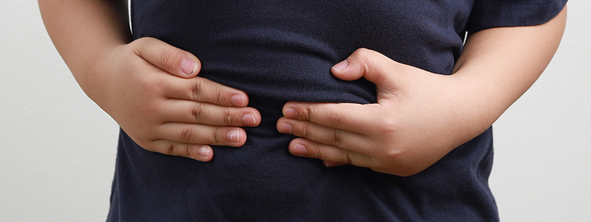 Child holding stomach in pain.