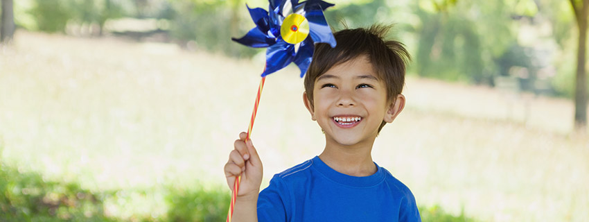 Little boy holding a blue pinwheel