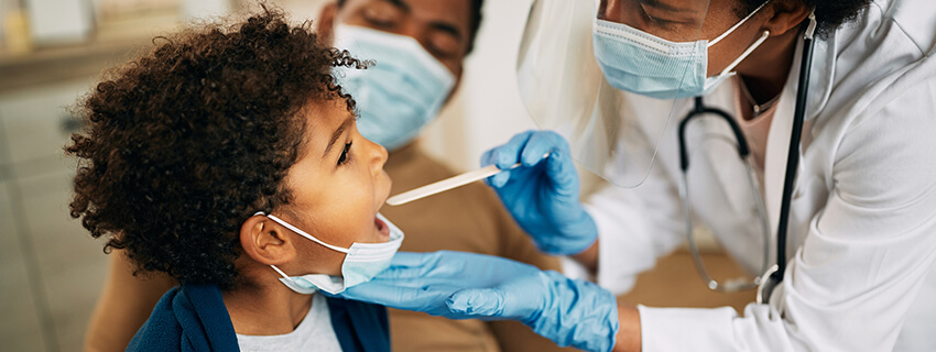 Doctor checking a boy's throat