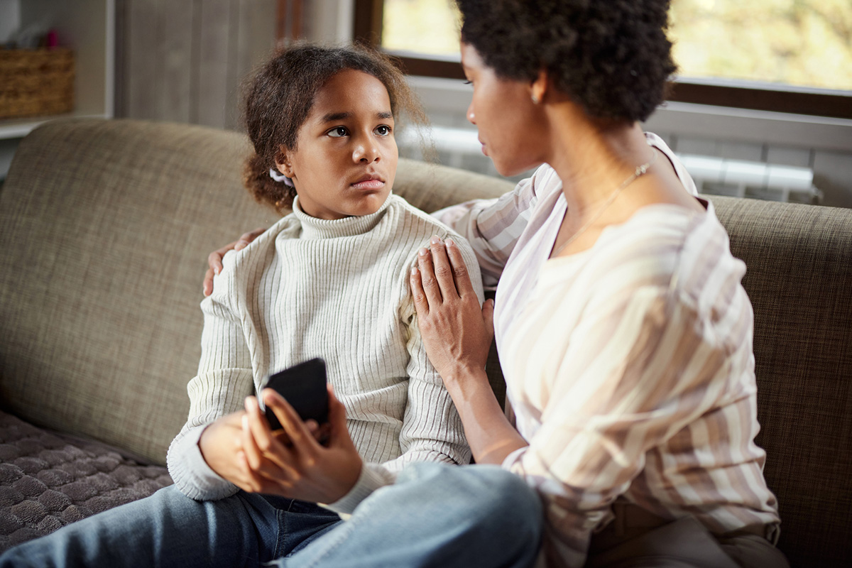 Sad girl talking to her mom in the living room.