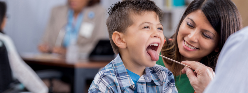 Doctor checking child's throat.