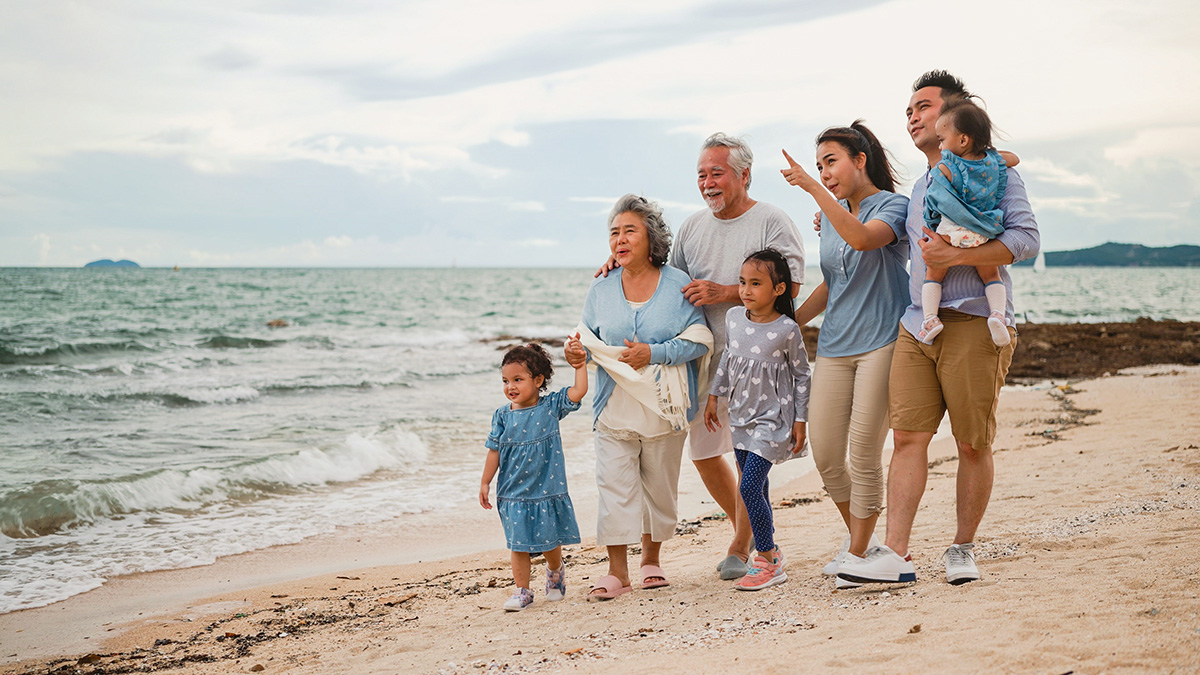 Multi-generational family taking a walk on the beach