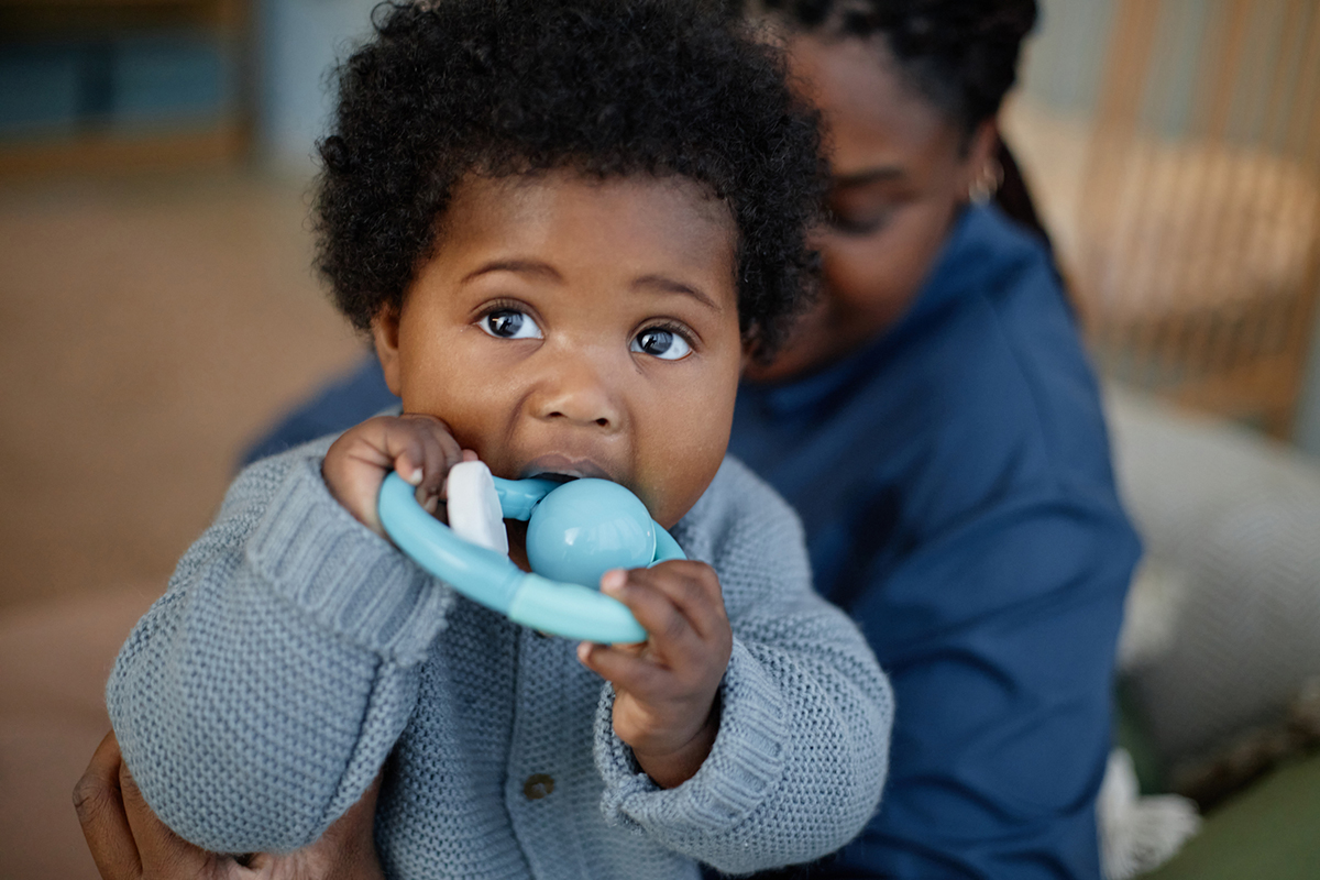 Portrait of Cute Little Baby Girl Biting Teether