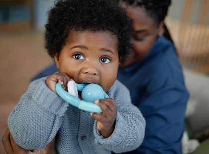 Portrait of Cute Little Baby Girl Biting Teether