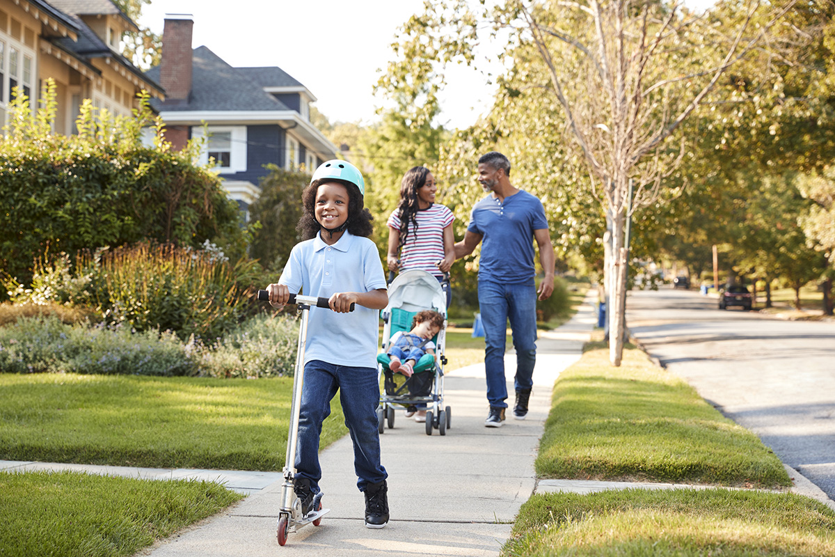 Family taking a walk together in a neighborhood.