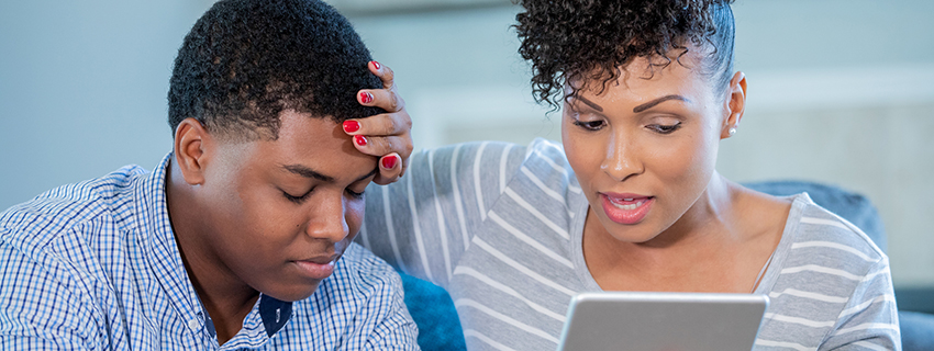 Mom and son talking to doctor on a tablet