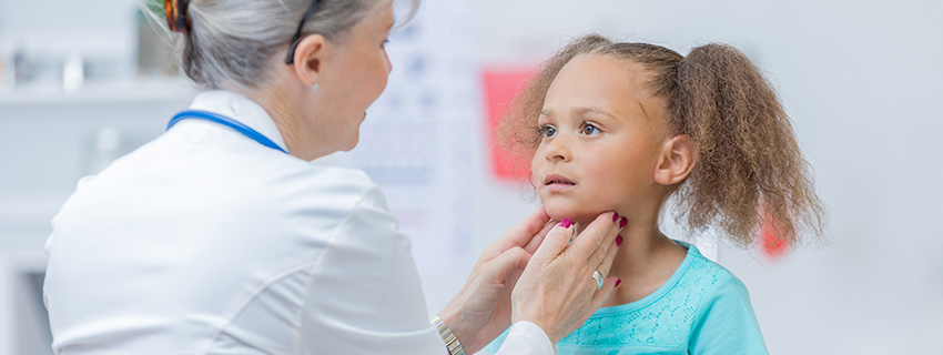 Doctor checking young girl's throat.