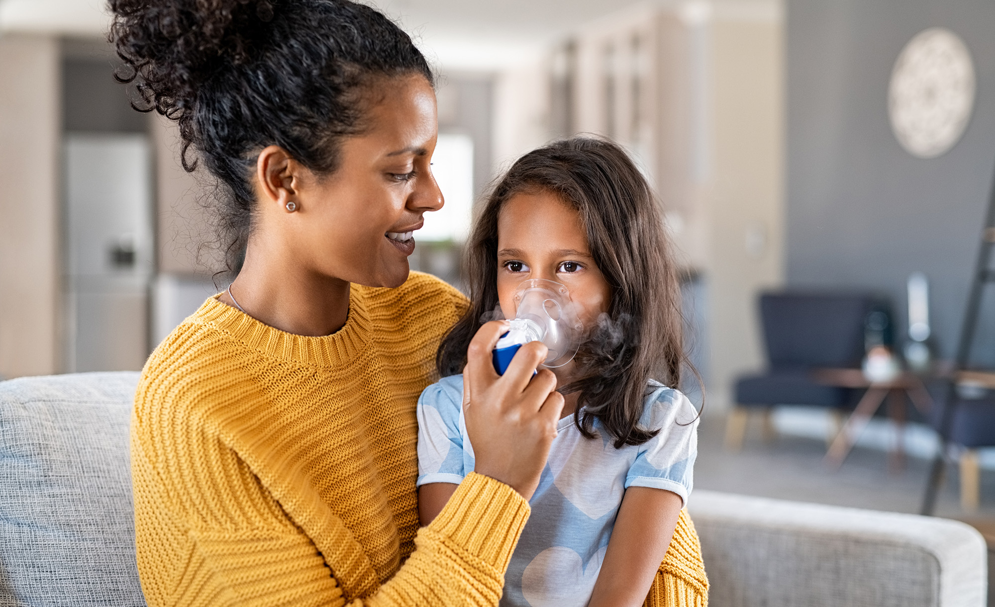 Mom helping child with her asthma inhaler