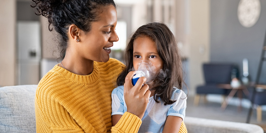 Mom helping child with her asthma inhaler