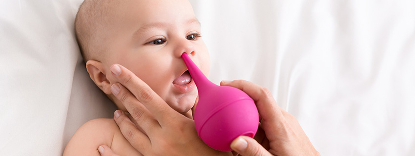 Parent suctioning their baby's nose.