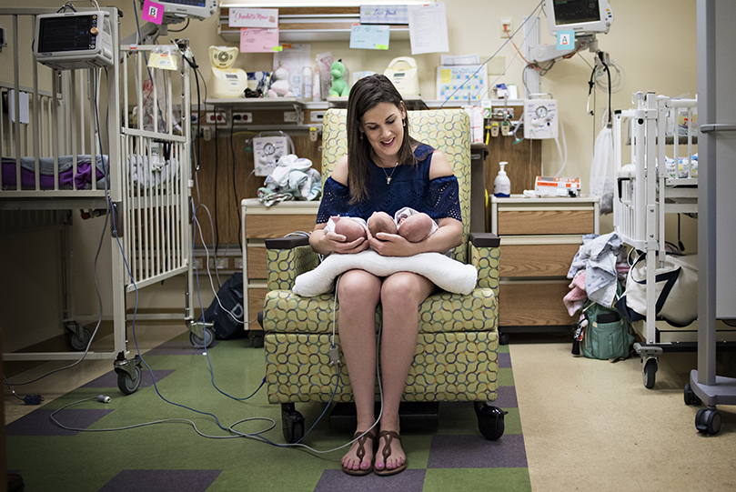Mom poses with her triplets in the NICU at CHKD