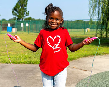 CHKD patient Grace Petway outside in a park with her jump rope.