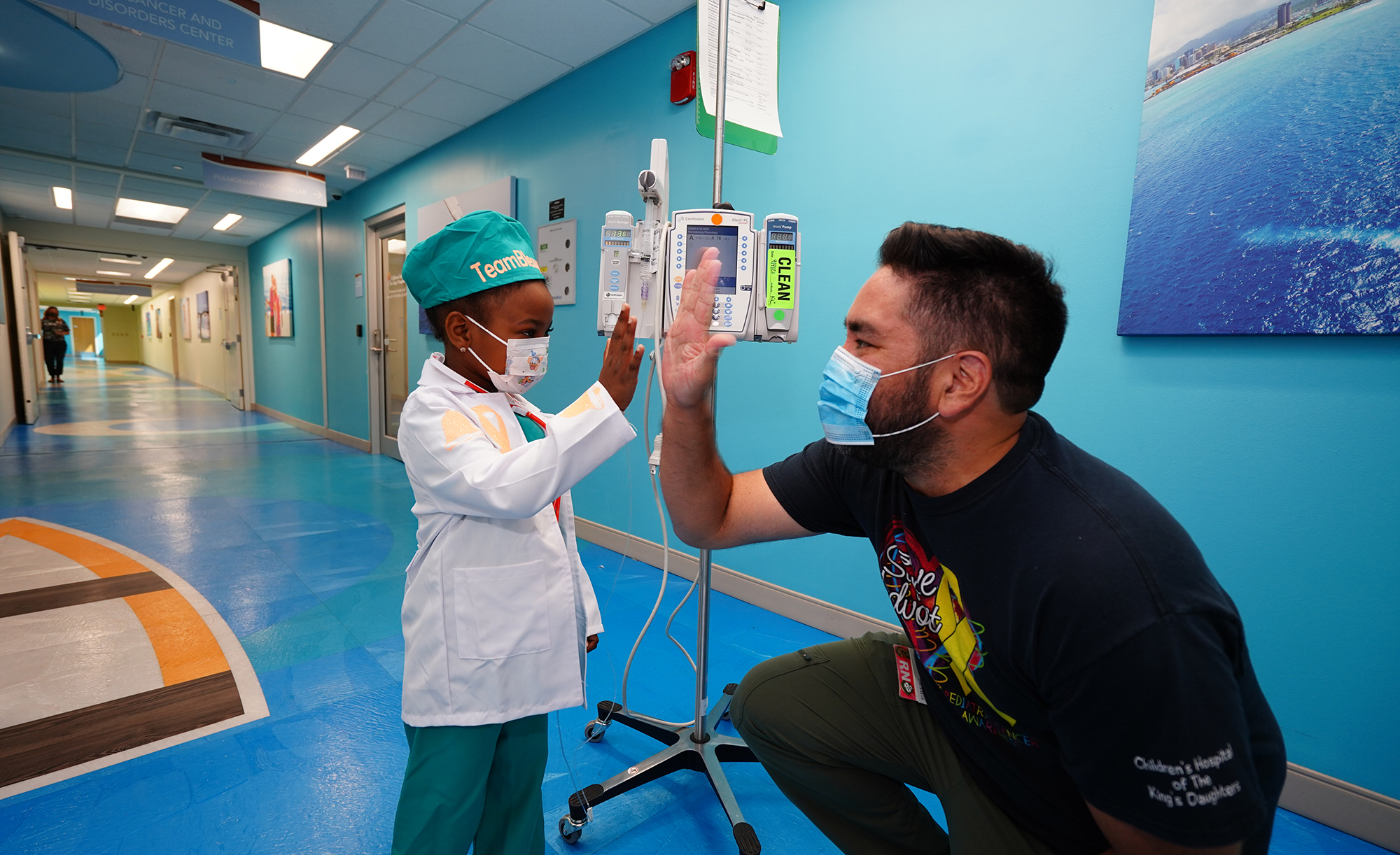 Nurse Rob High Fiving A Young Cancer Patient Who Just Completed Treatment