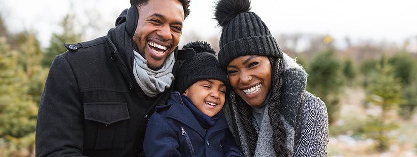 Smiling Black family wearing winter gear.